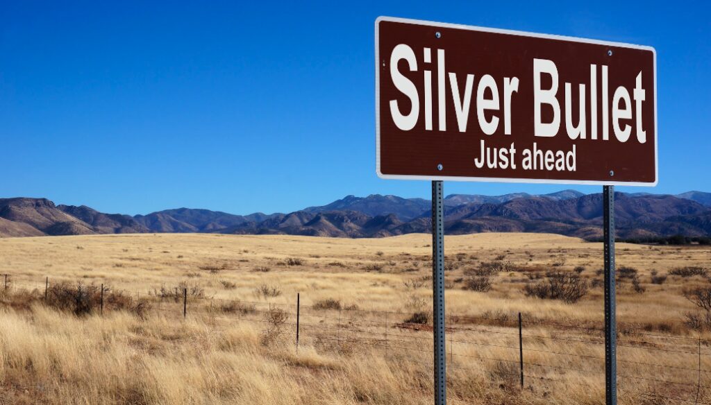 Silver Bullet brown road sign with blue sky and wilderness